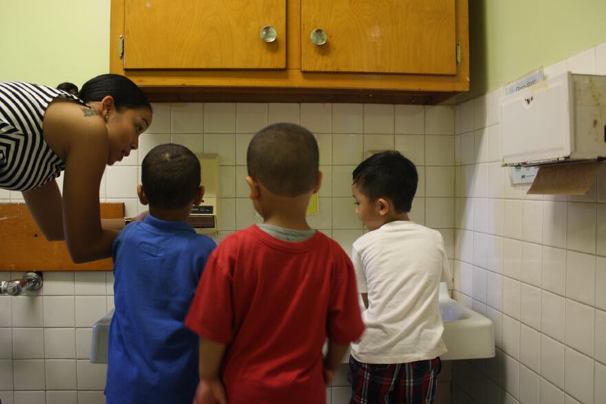 Pre-K teacher Khadija Prowell shows students how to wash their hands on the first day of school at Grand Street Settlement.