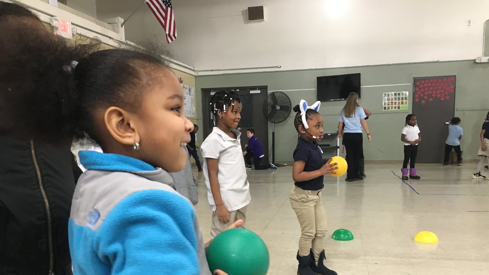 Macomb Montessori kindergartner London Comer plays with a ball during a Playworks session at her school.