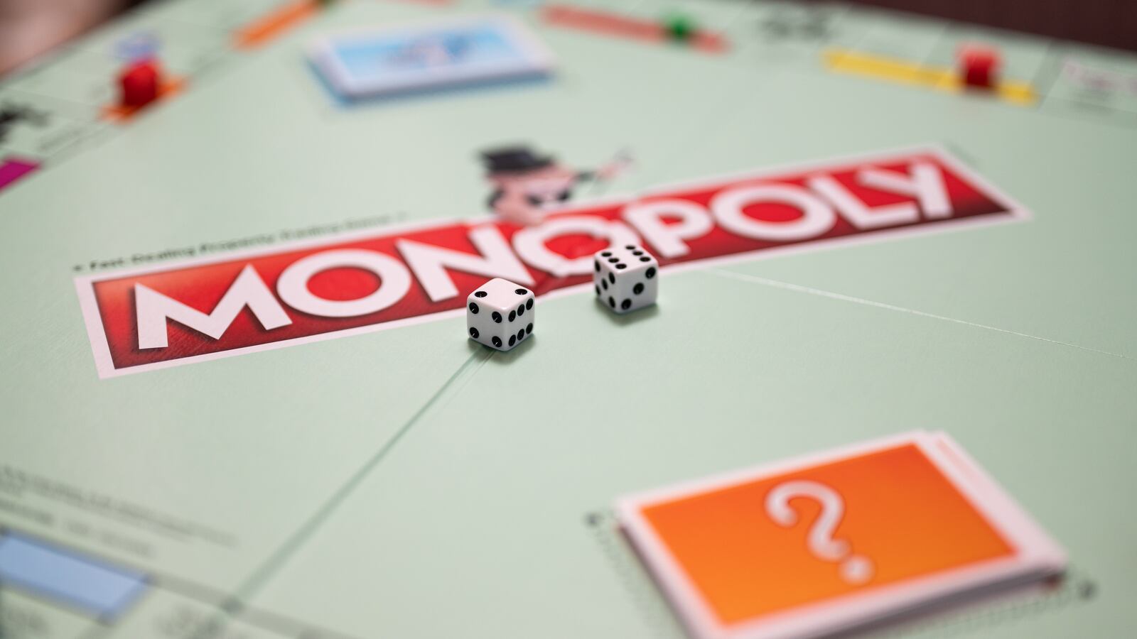 Two six-sided dice sit at the center of a Monopoly board.