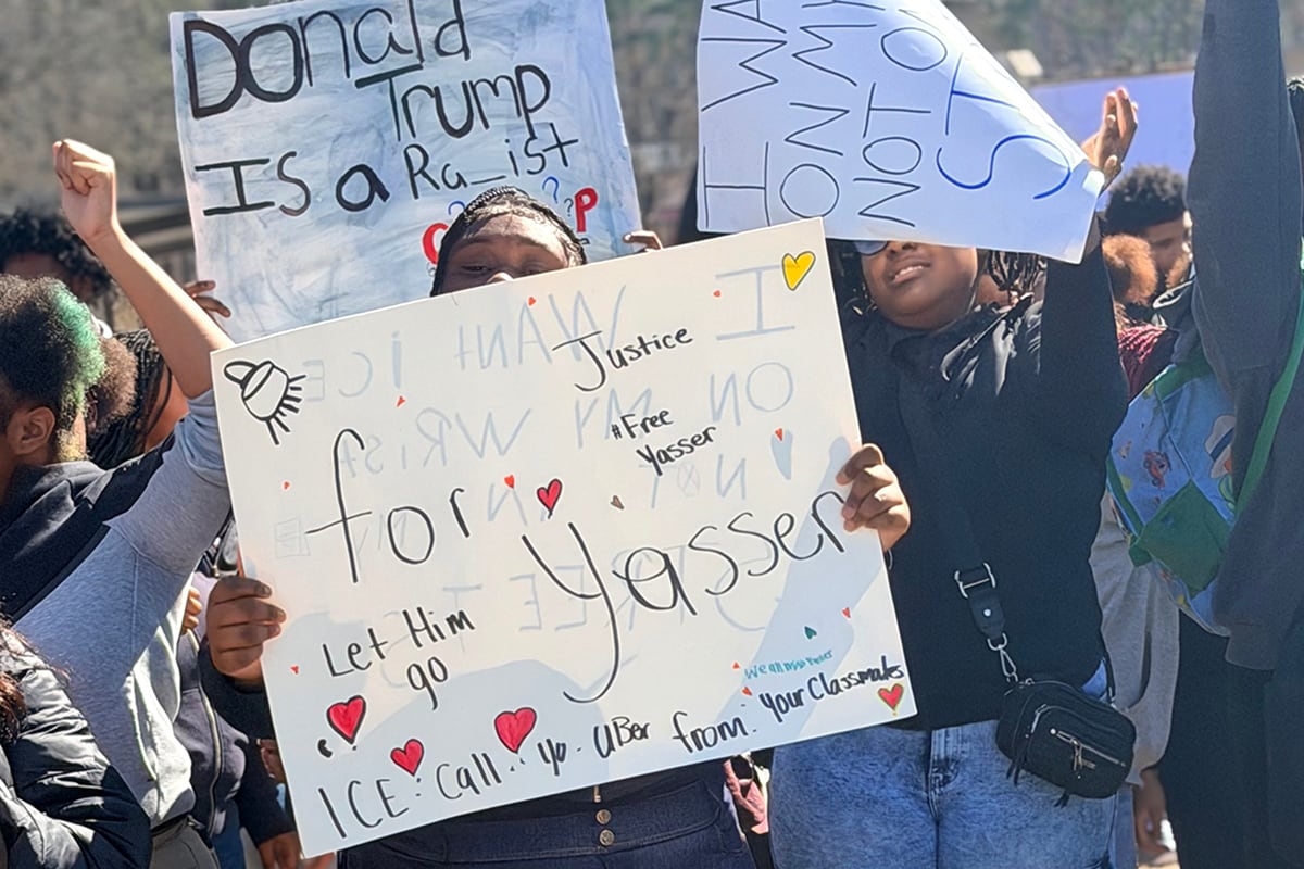 Students hold signs.