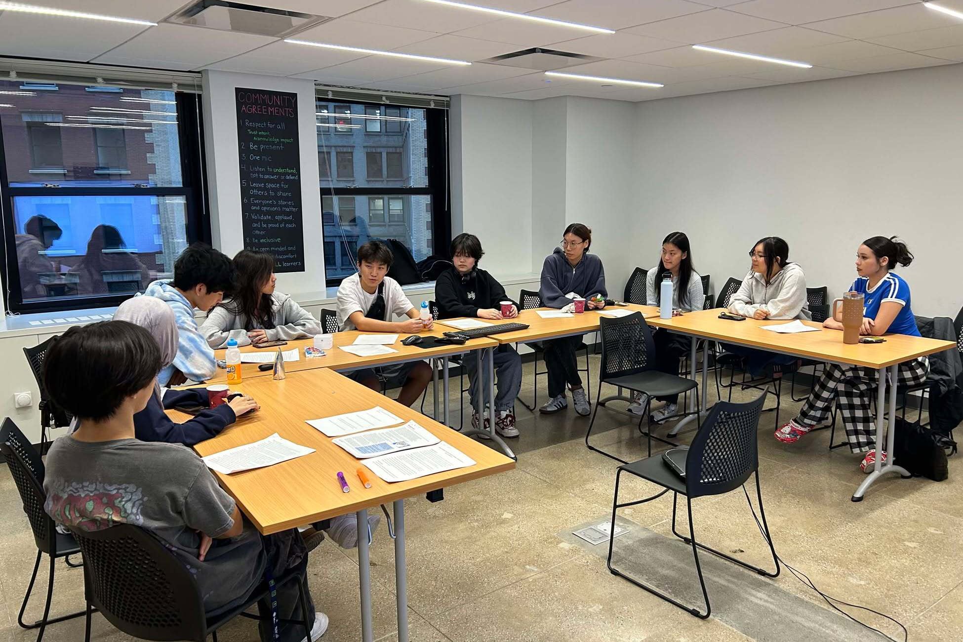 A group of students work in a white classroom