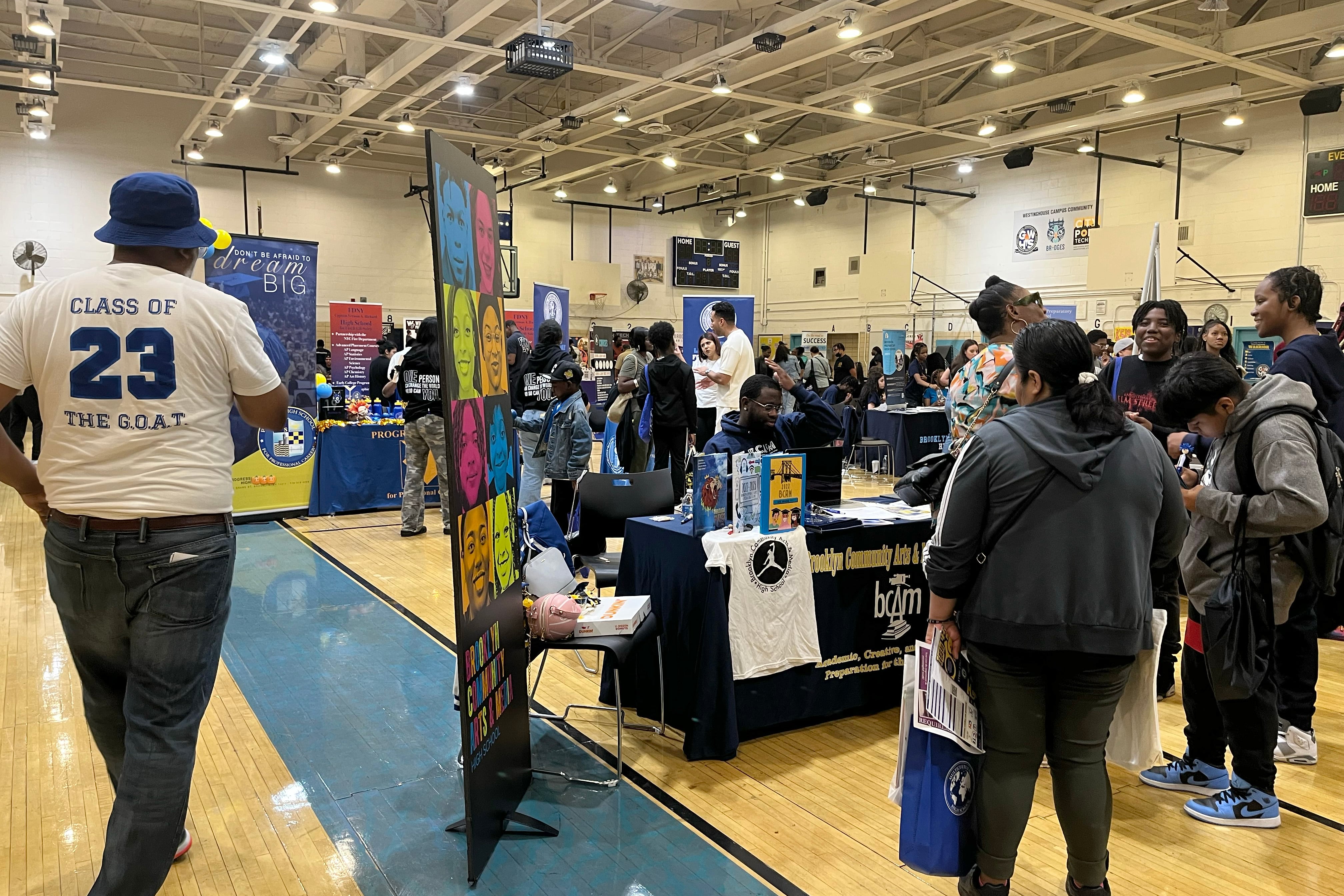 Families gather in George Westinghouse Career and Technical Education High School’s gymnasium, where local high schools have set up tables to chat with prospective students about their schools.