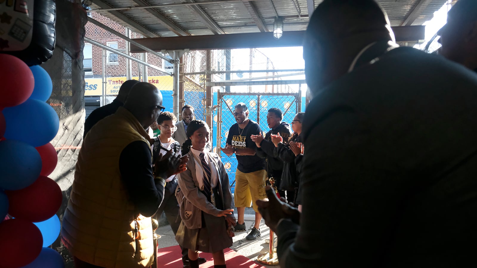 A photograph of a group of people on a red carpet.