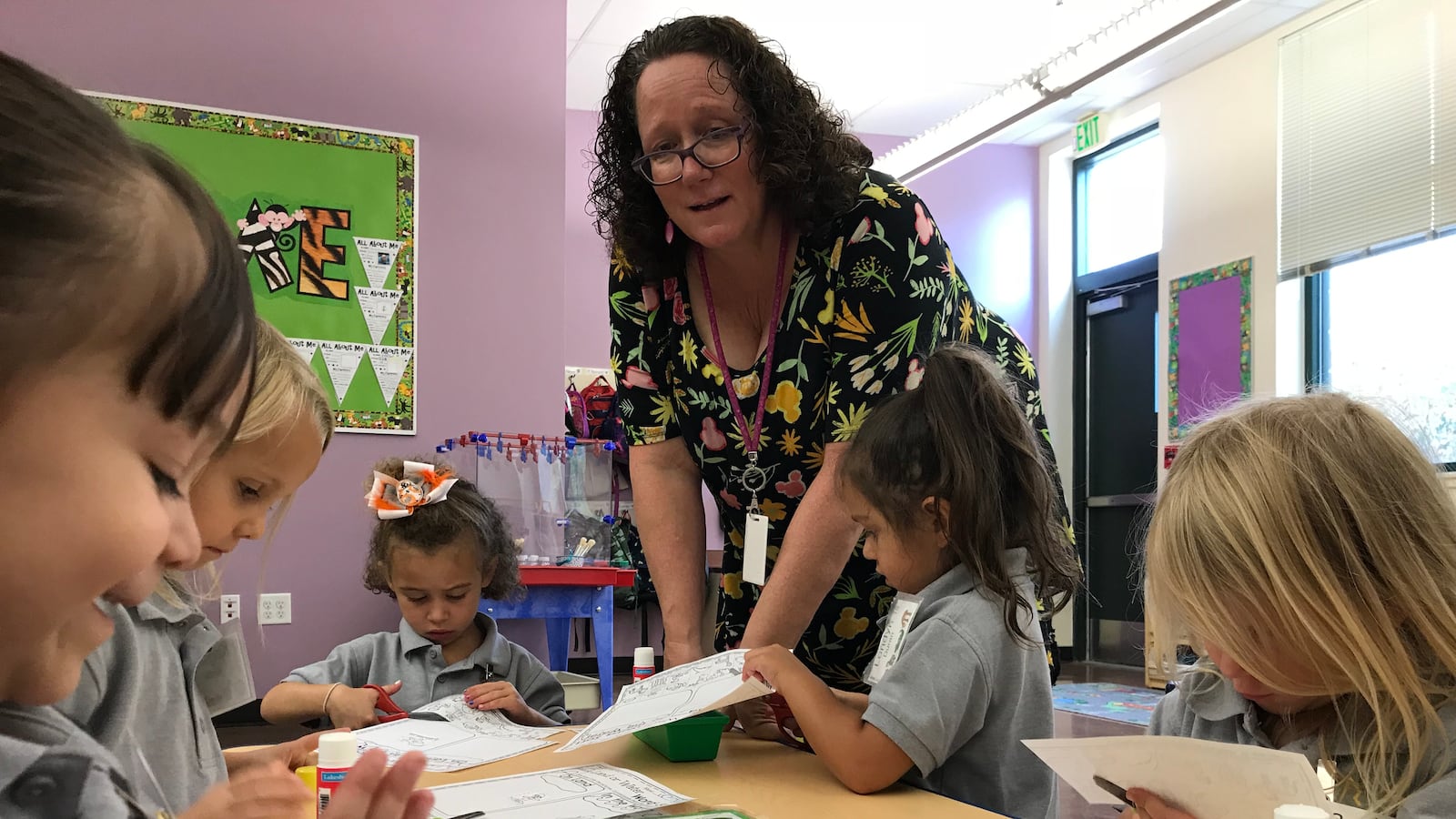 Mary Ann Mahoney helps her preschool students with a cutting and pasting lesson.