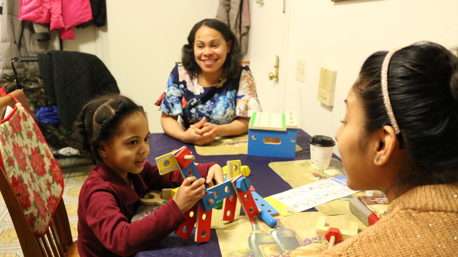 Hadasa Florian, 4, plays with a toy during a home visit with a representative from Rising Ground. The Public Prep charter network has partnered with nonprofits to visit family's homes and help parents prepare their children for school.