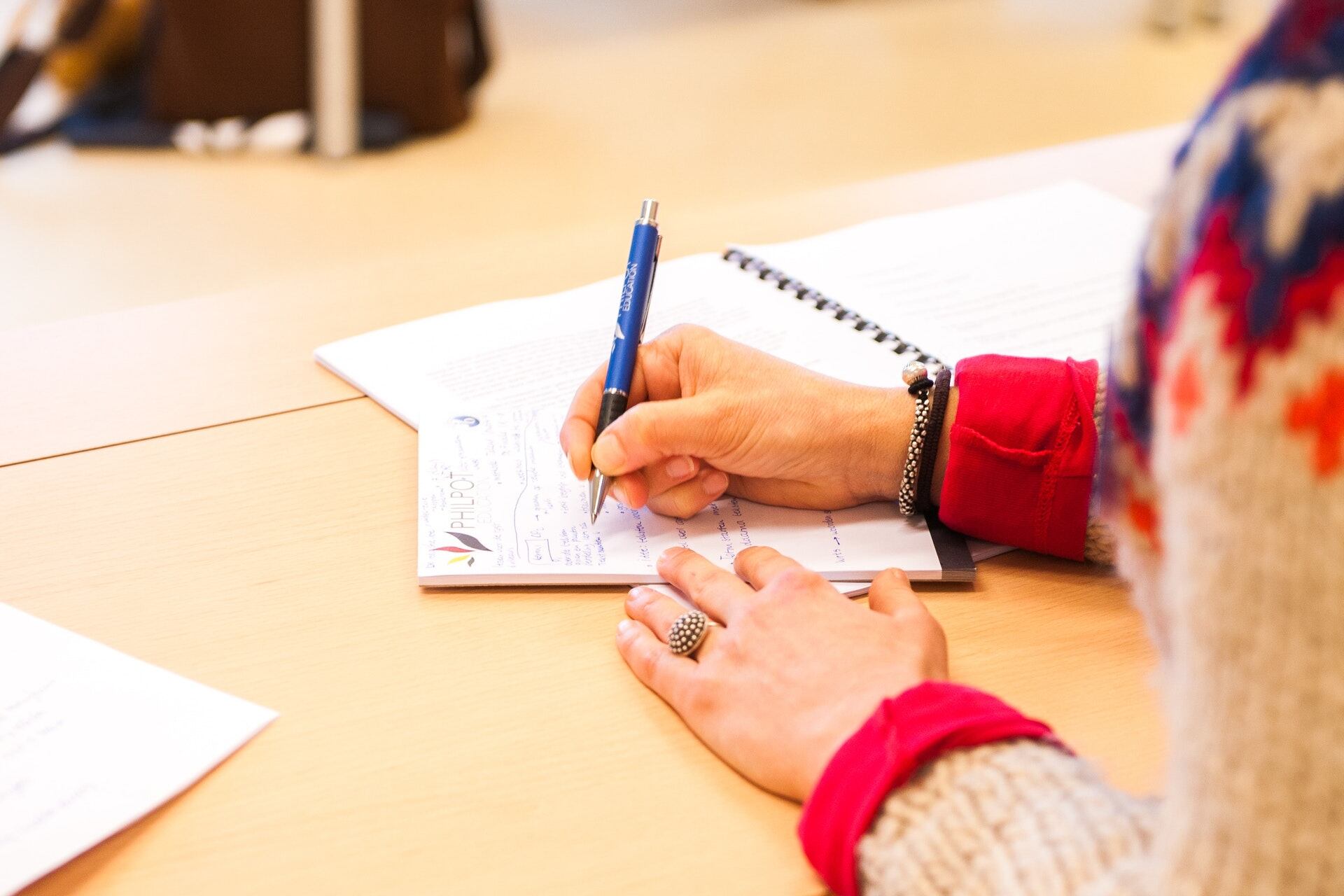 Close up of student writing in a notebook.