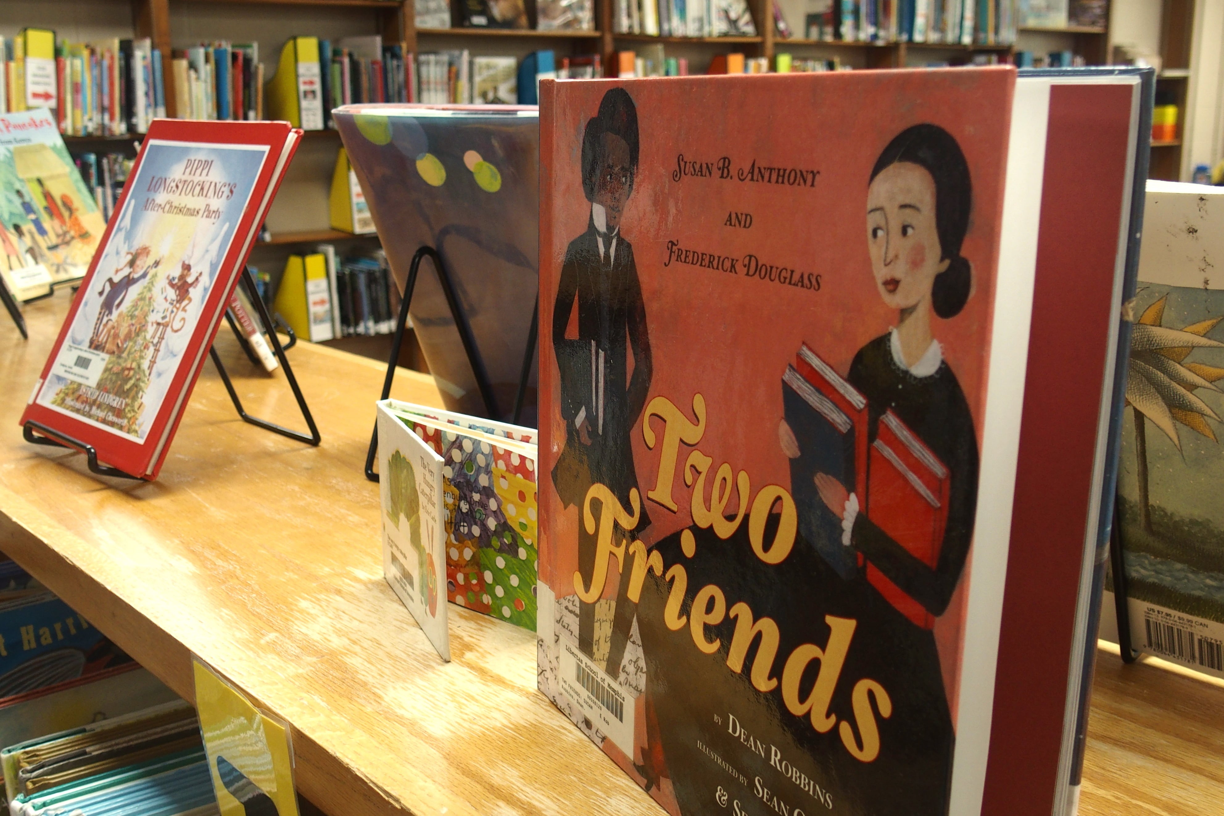 The book “Two Friends” on a display stand on a shelf in an elementary school library