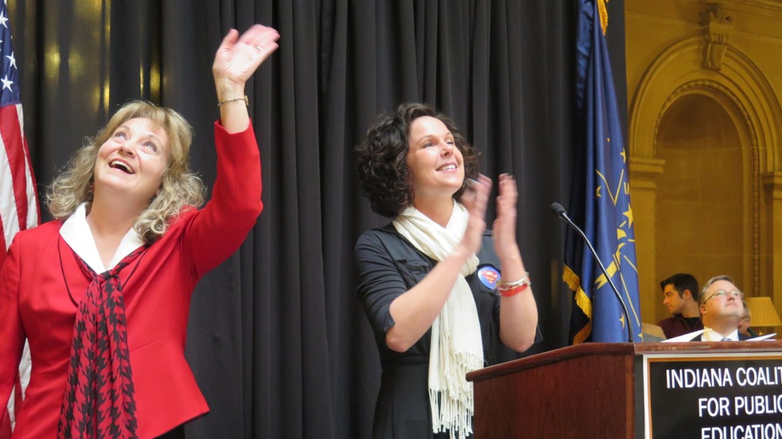 State superintendent Glenda Ritz waves to supporters on the second level of the Statehouse as she joins Marisa Graham, vice president of the Anderson teachers union, at the podium at Monday's rally.