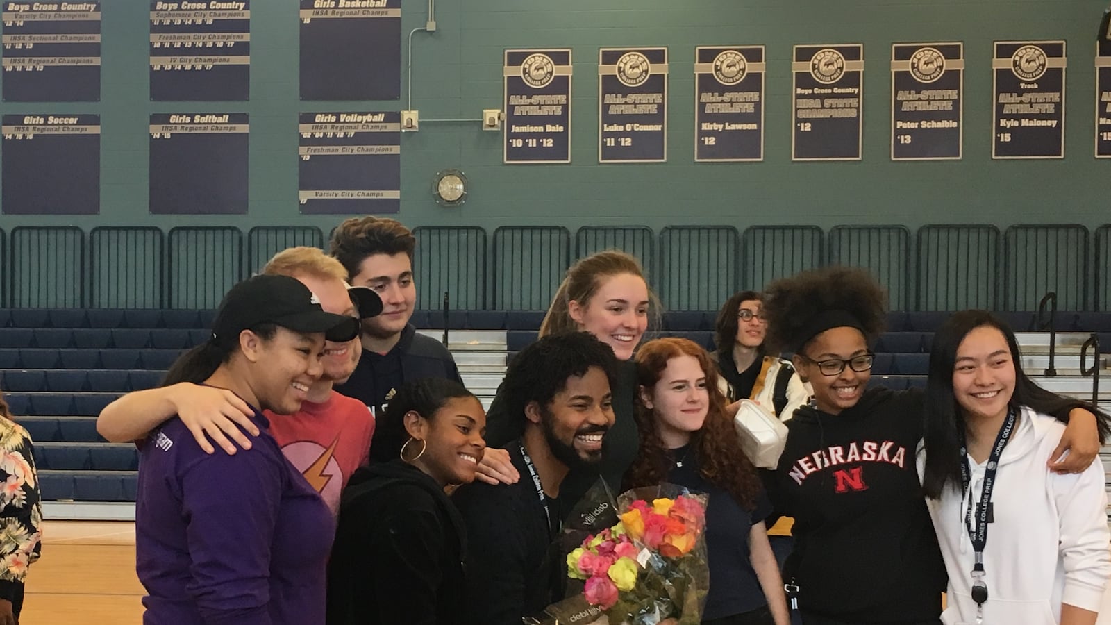 Brian Coleman, pictured center with flowers, poses with students from Jones College Prep on the day of his announcement
