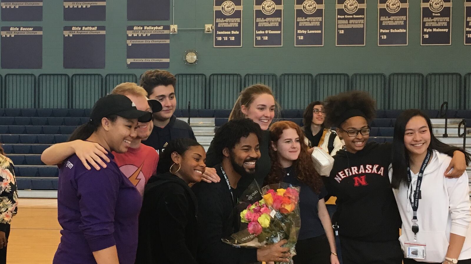 Brian Coleman, pictured center with flowers, poses with students from Jones College Prep on the day of his announcement