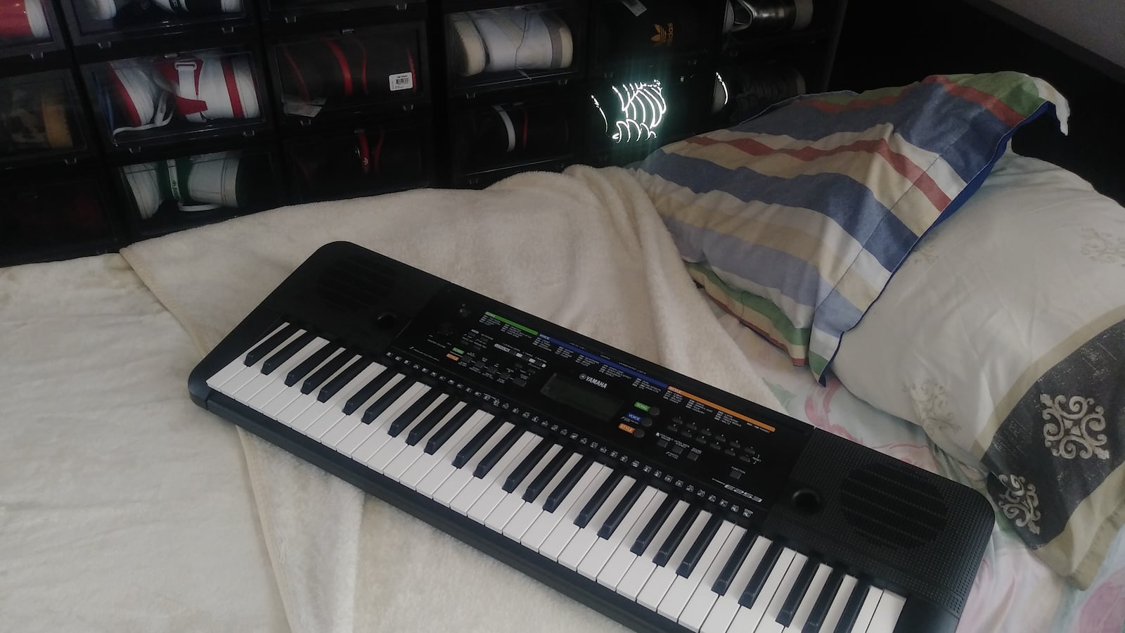 An electronic keyboard atop a bed.