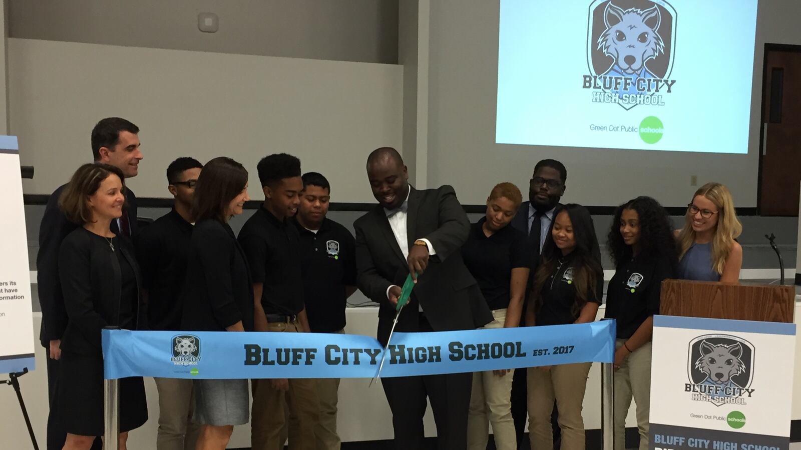 Principal Jonas Cleaves cuts the ribbon at Bluff Hills High School's opening day ceremony. He is surrounded by students, faculty and leaders of Green Dot and the State Board of Education.