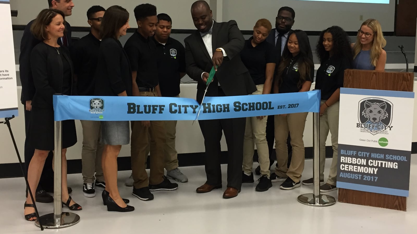 Principal Jonas Cleaves cuts the ribbon at Bluff Hills High School's opening day ceremony. He is surrounded by students, faculty and leaders of Green Dot and the State Board of Education.