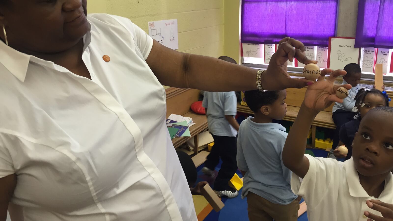 Detroit Pre-K teacher LaWanda Marshall shows off the work of a student who had the idea to name a newly arrived set of balls after planets.