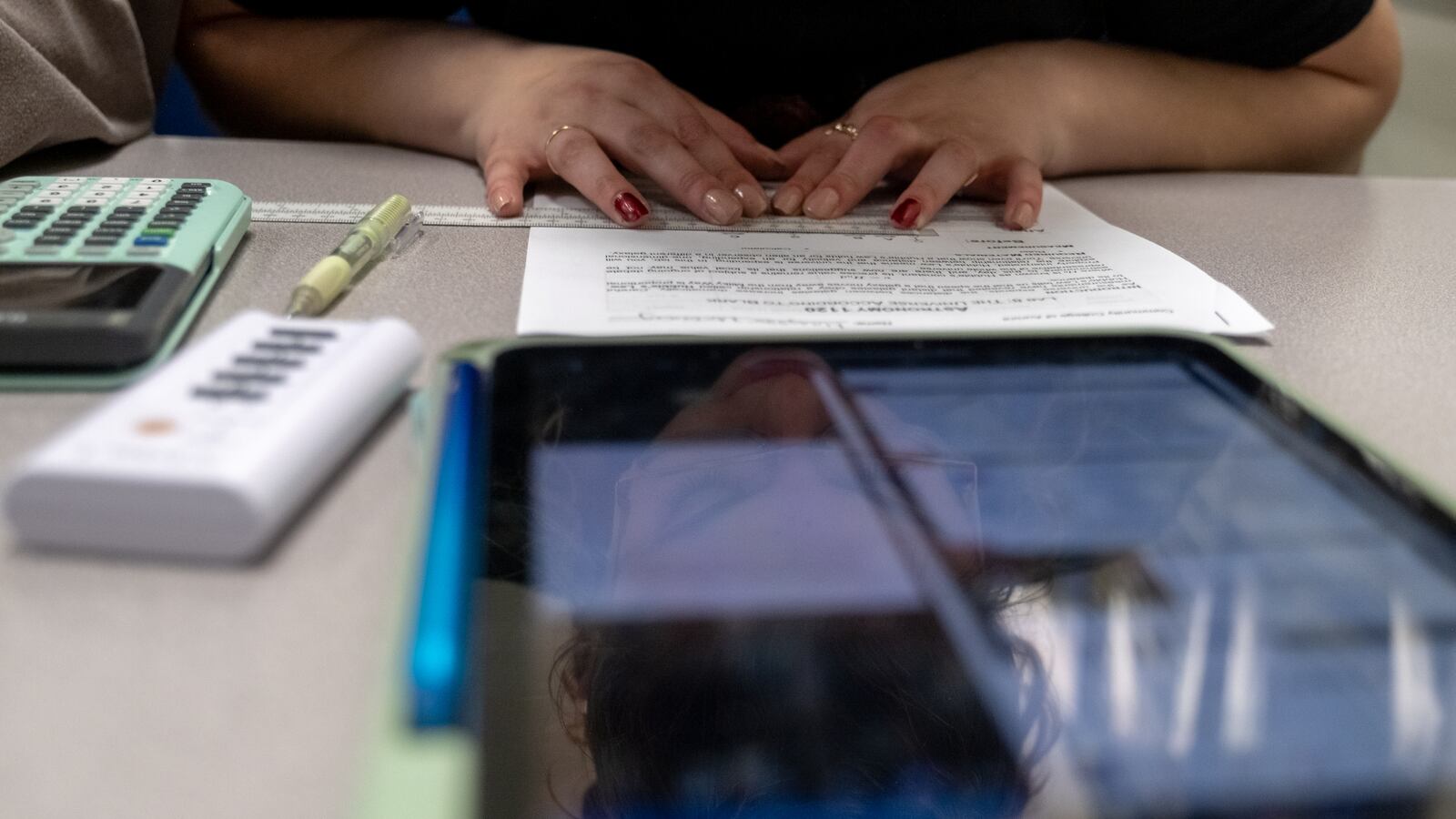 A woman's hands rest on a piece of paper.