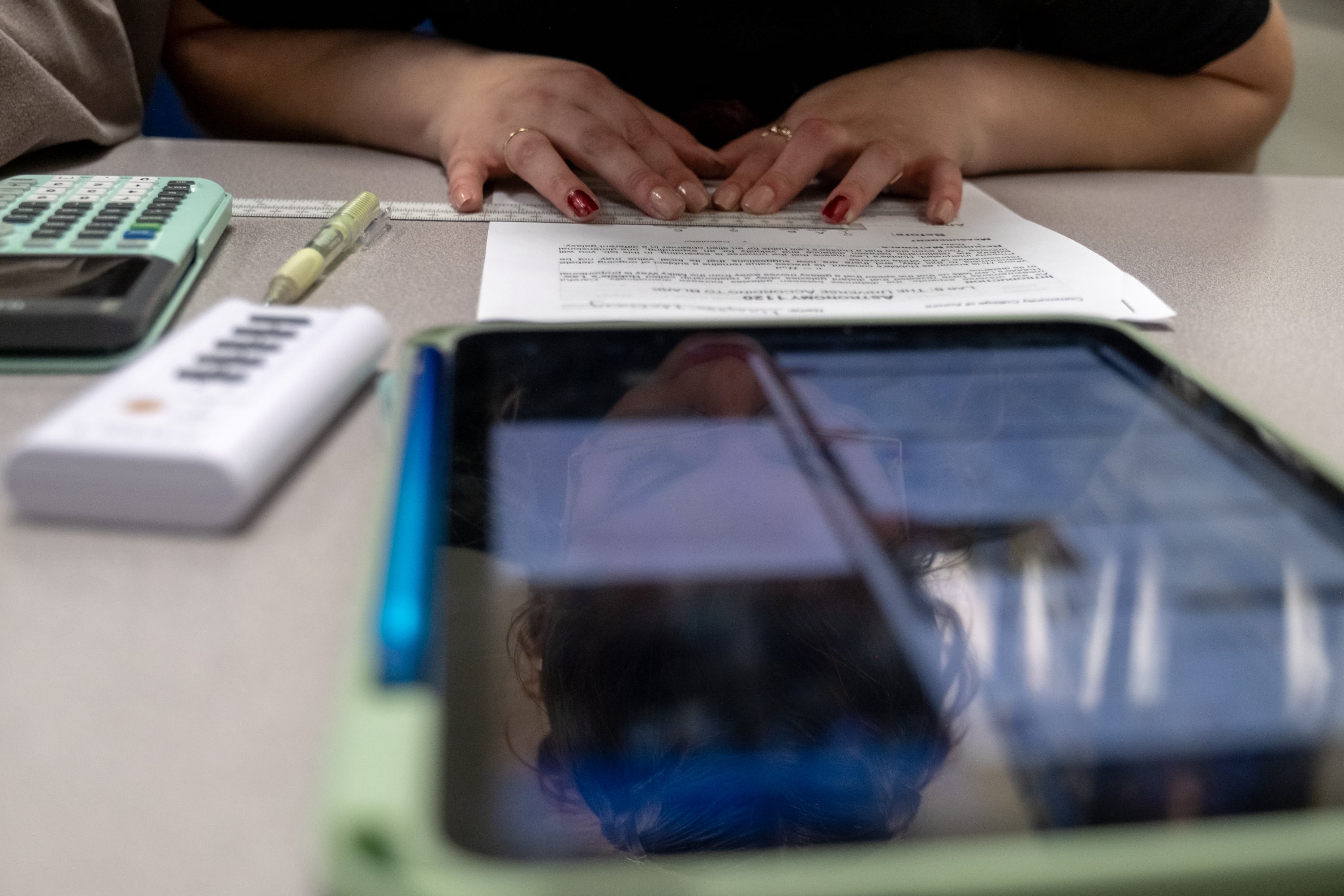 A woman's hands rest on a piece of paper.