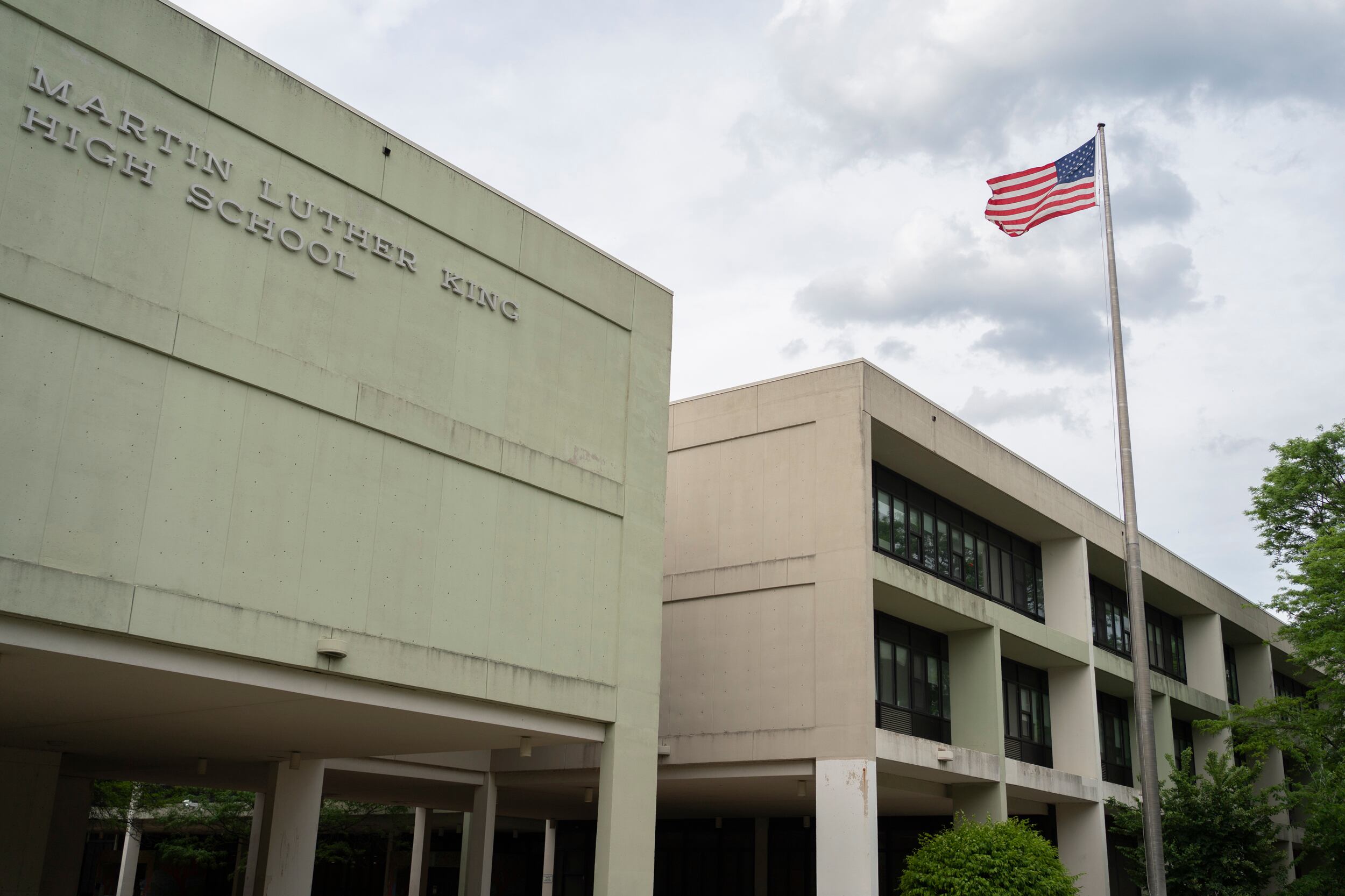 A tan school building with a sign that reads “Martin Luther King High School”