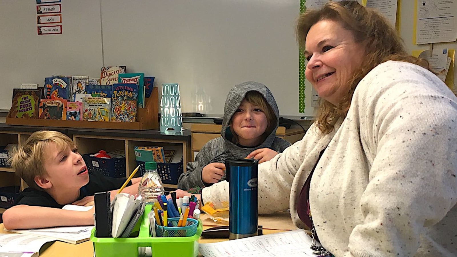 Wendy McSwain, a paraprofessional at Heiman  Elementary School in Evans, works with two students in a math group.