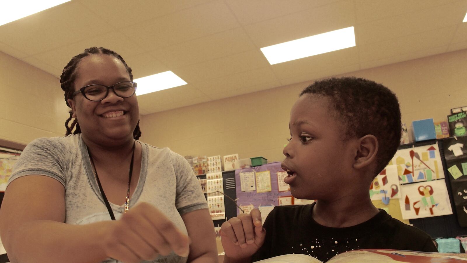 Teacher Dorian Lloyd helps rising first-grader Nykari McNeal sound out words during a state-funded reading camp at Cornerstone Prep Denver, a Memphis charter school in the Achievement School District.