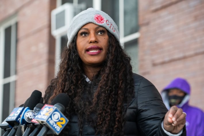 A woman speaks to reporters in front of a Chicago Public School building on the South Side.