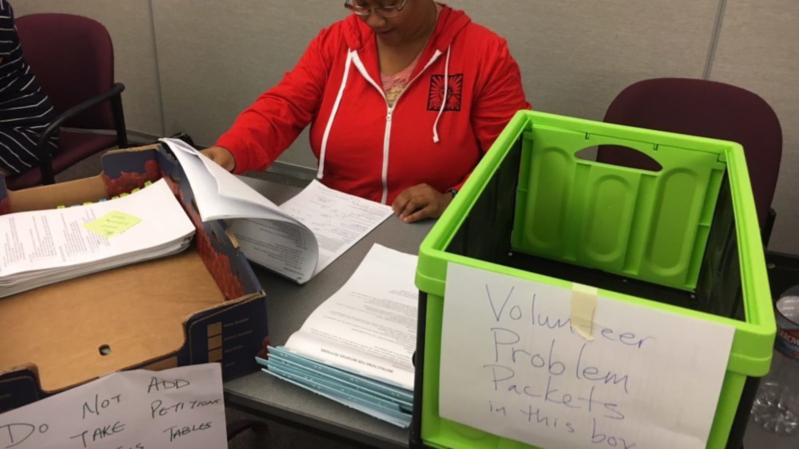 Joi Lin, a Boulder Valley Education Association employee, checks notary pages on petitions for Great Schools, Thriving communities. (Erica Meltzer/Chalkbeat)