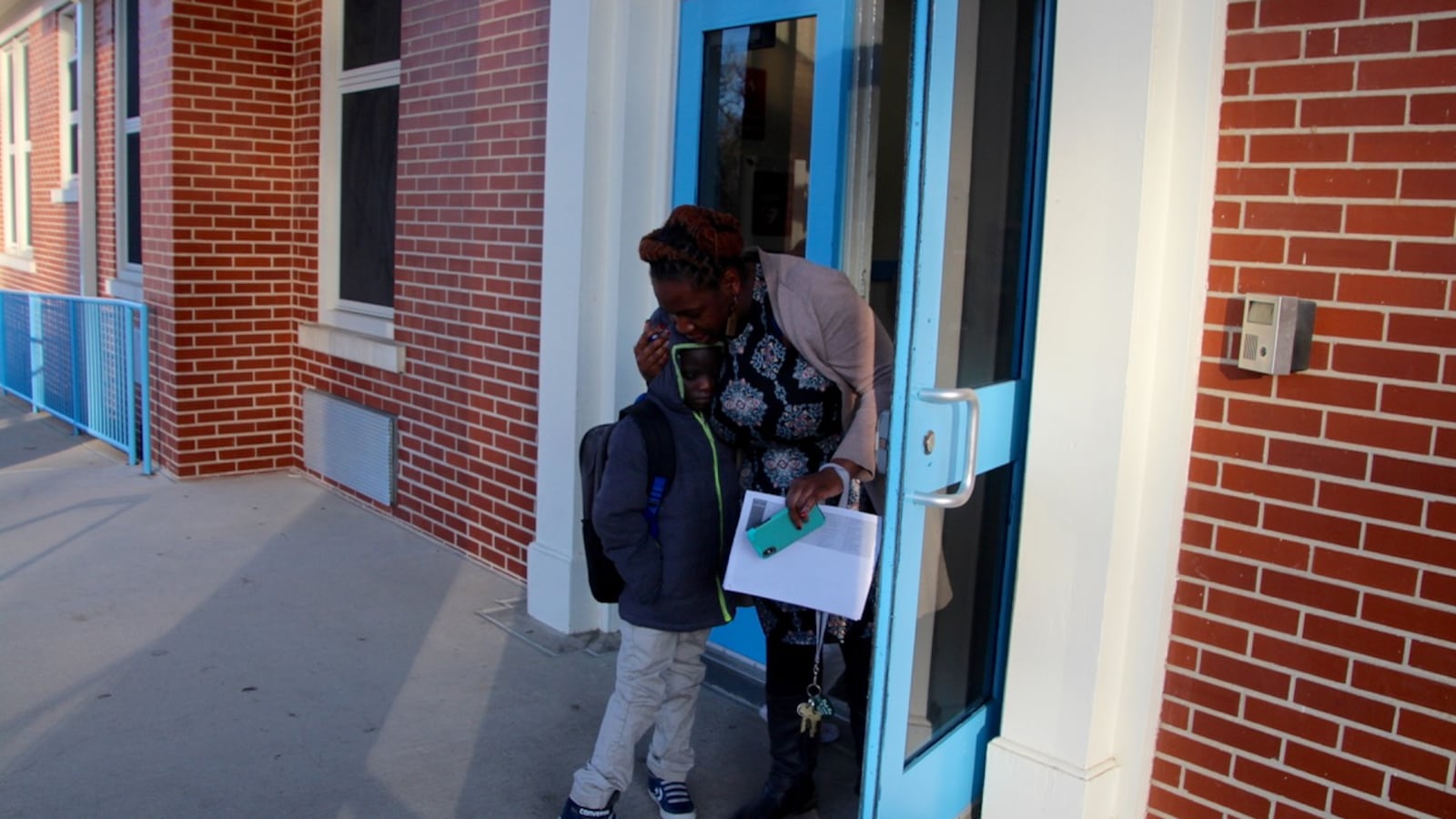 A teacher greets a student at Georgian Hills Achievement Elementary School. One water source at Georgian Hills had three times the state’s threshold for safe water, which is 20 parts of lead per billion parts of water.