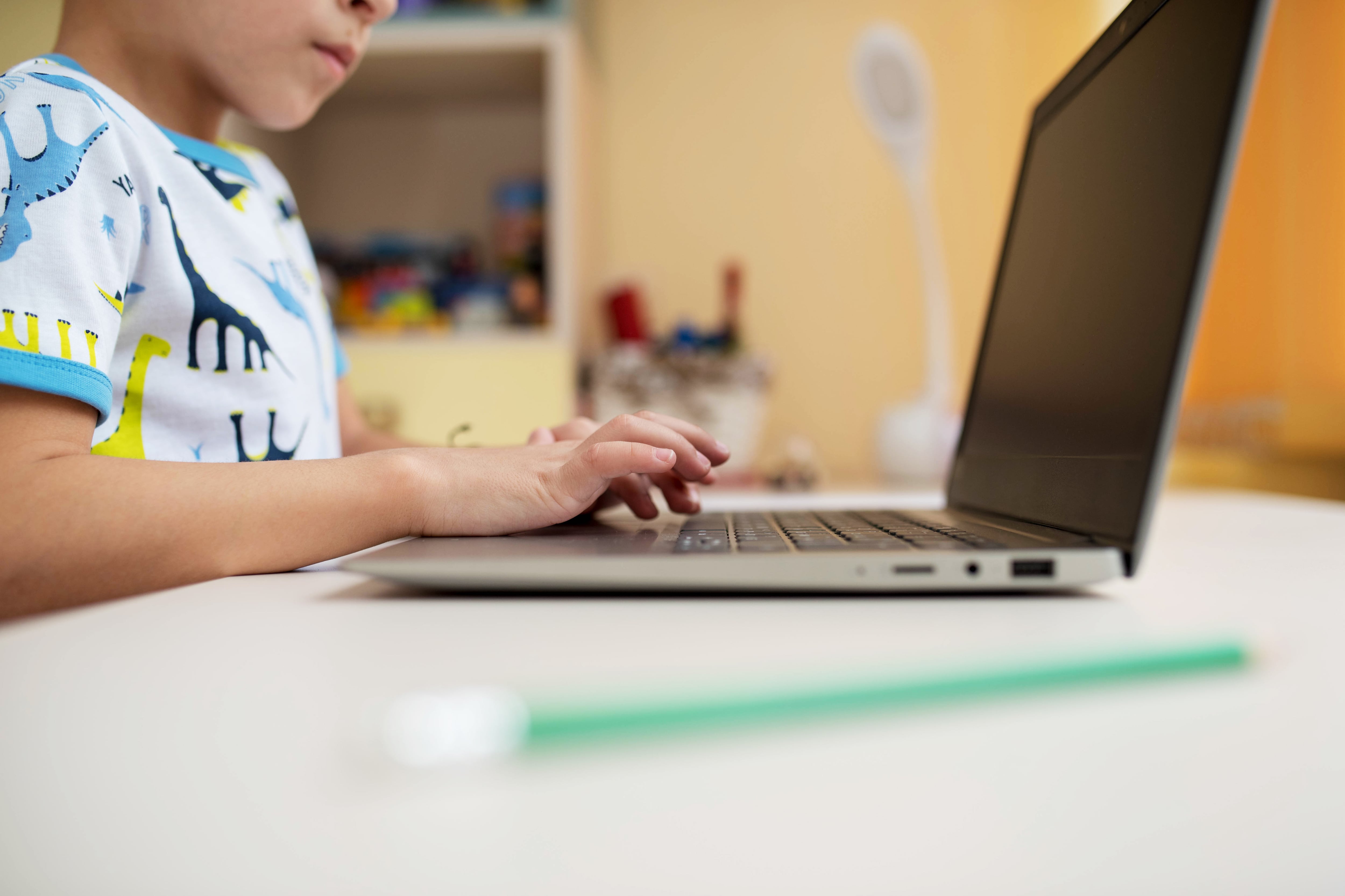 A little boy plays on a laptop.