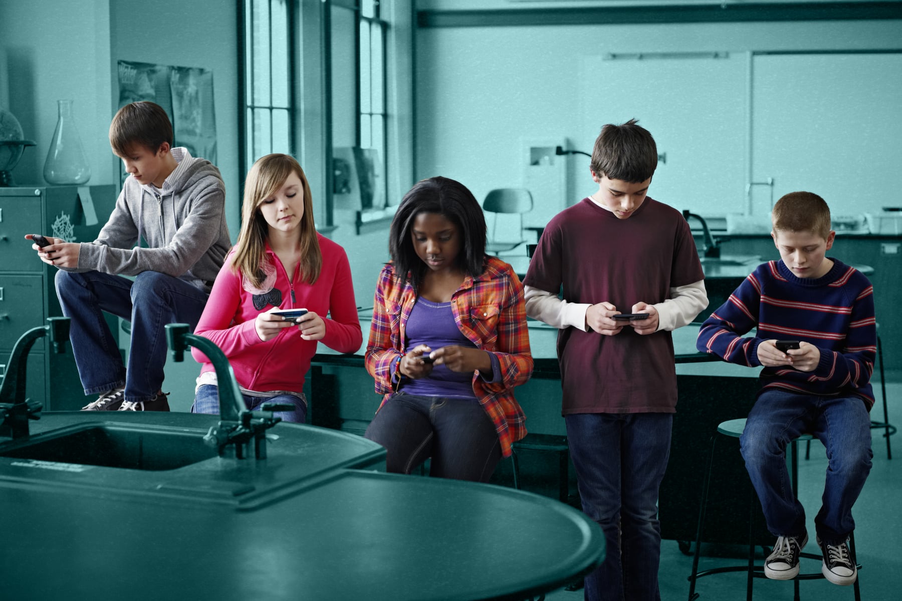 Group of students on smartphones in a classroom.