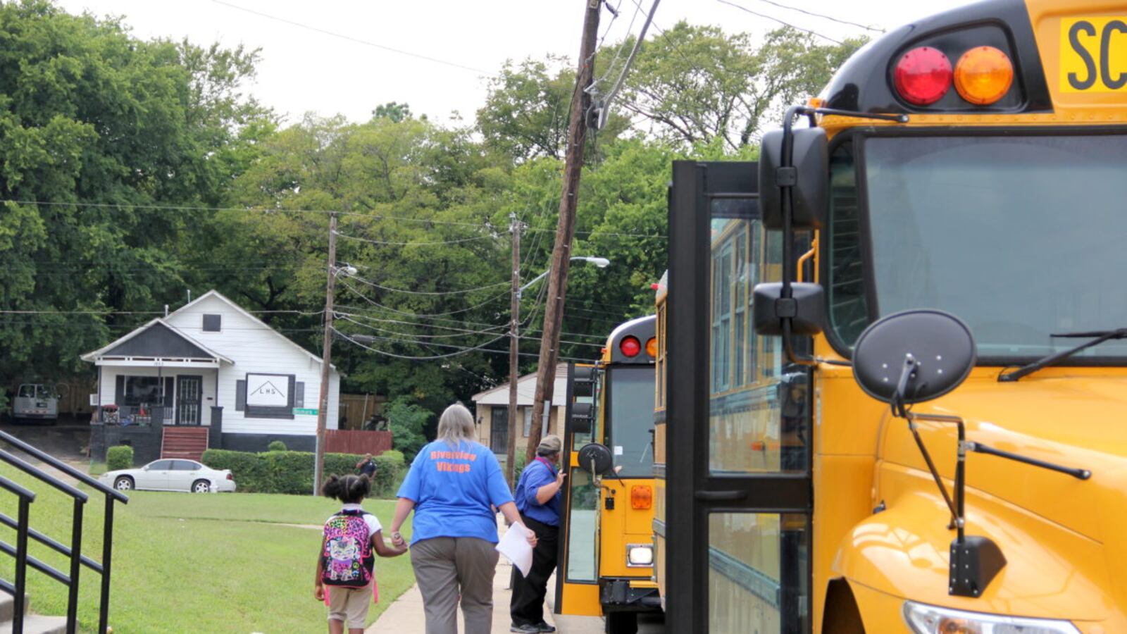 Riverside teachers and staff help students find the right buses at the start of the school year.