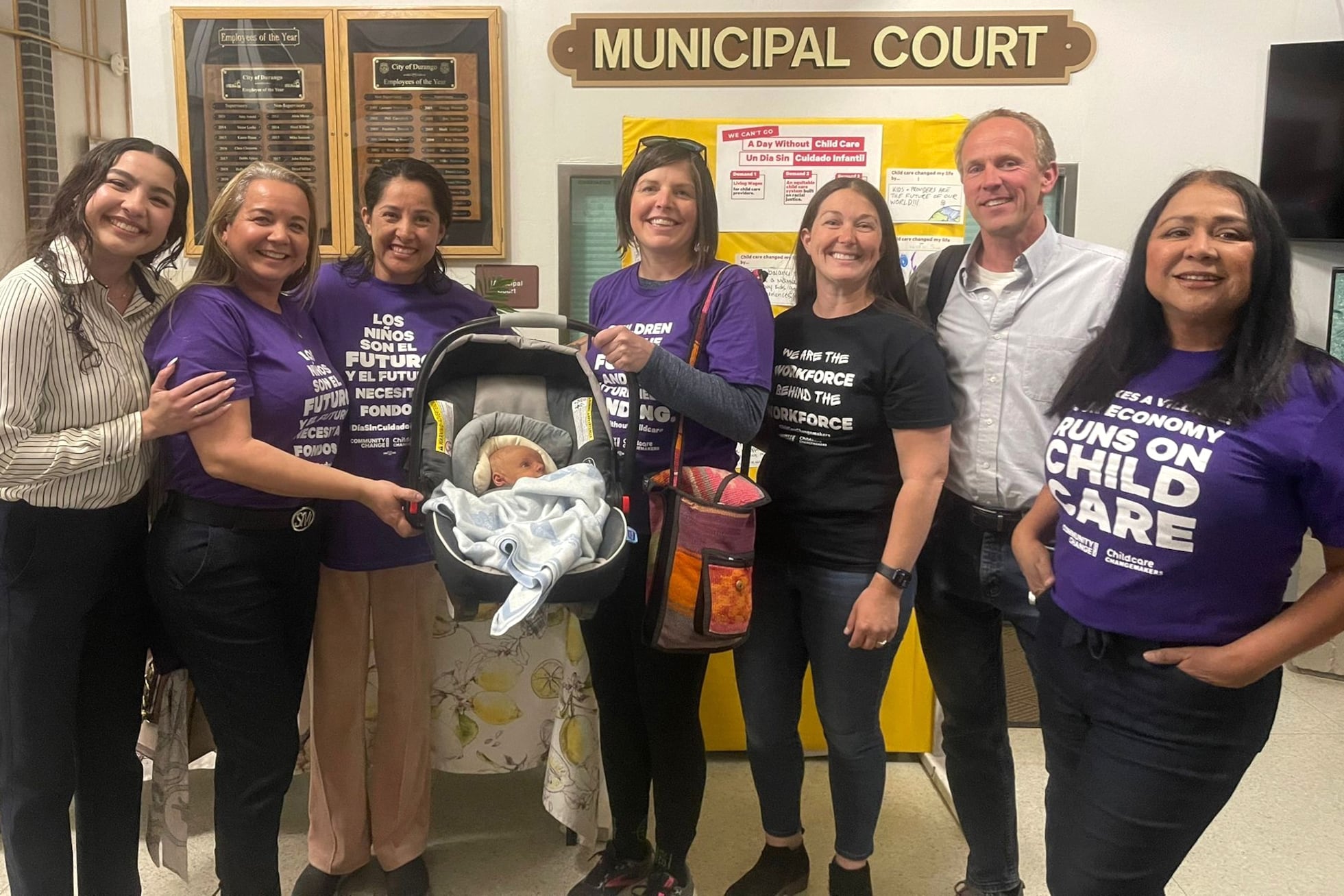 A group of seven adults and a baby in a carrier