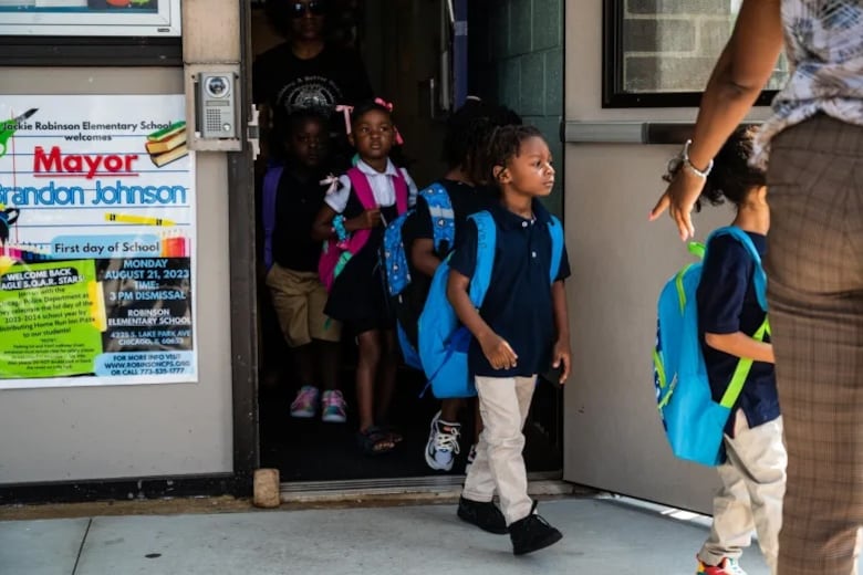 Kindergartners line up for free pizza during a back-to-school event at Jackie Robinson Elementary School in Bronzeville.