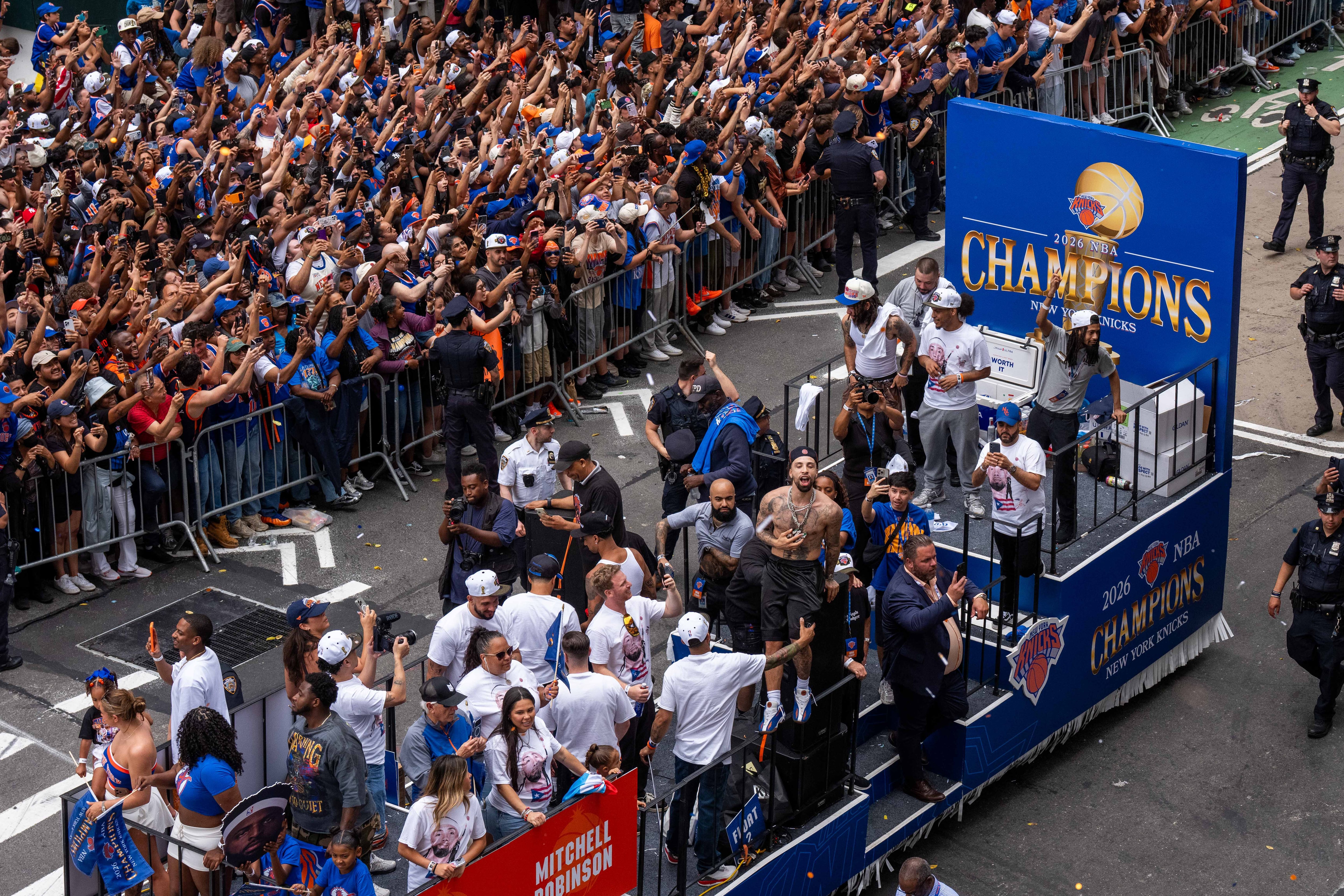 A huge crowd cheers as a float goes by.