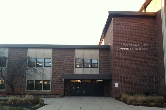 The photo shows a multi-story brick building with the words “Thomas Carr Howe Community High School” on the right.