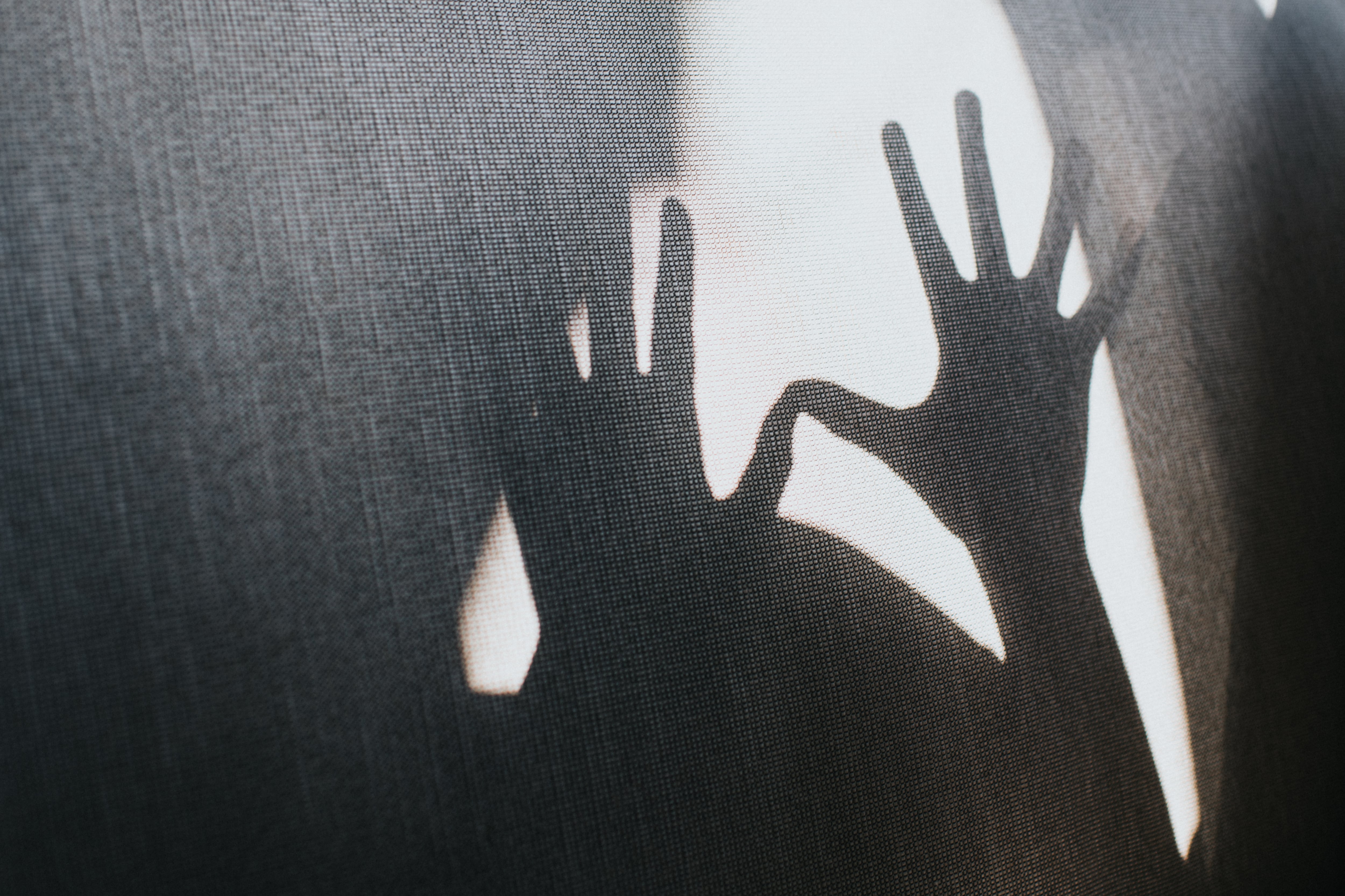 A conceptual, shadowy image with outstretched hands.