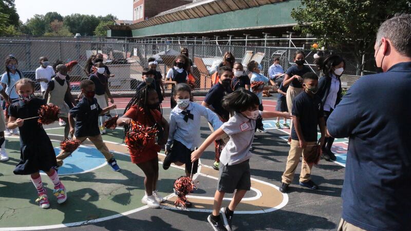 Students dance together on a blacktop playground on the first day of school in New York City.