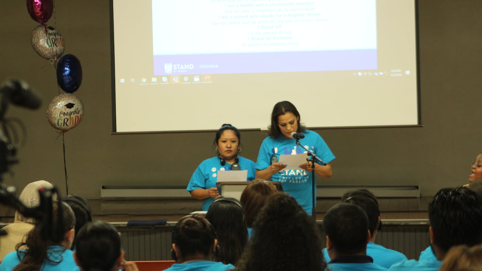 Stand UP parents Edith Aguilar and Angelina Olmedo read their organization's pledge at a graduation ceremony Wednesday.
