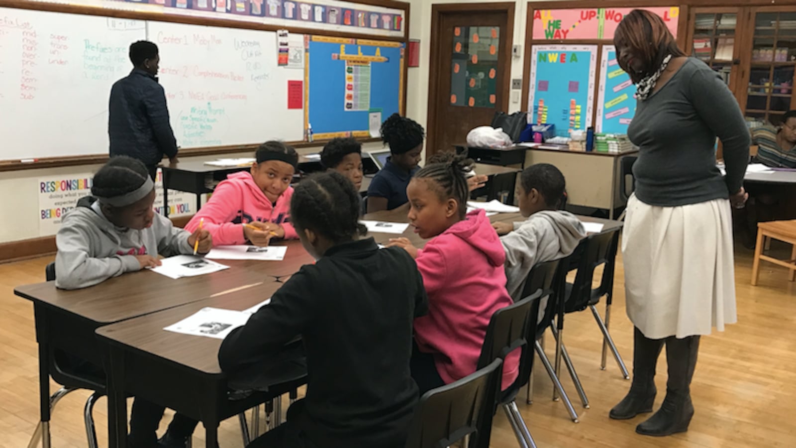 Principal Alisanda Woods checks on a student writing assignment in a sixth-grade English class at Detroit's Bethune Elementary-MIddle School.