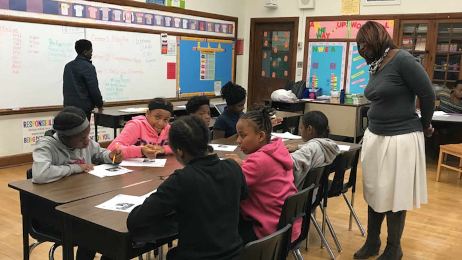 Principal Alisanda Woods checks on a student writing assignment in a sixth-grade English class at Detroit's Bethune Elementary-MIddle School.