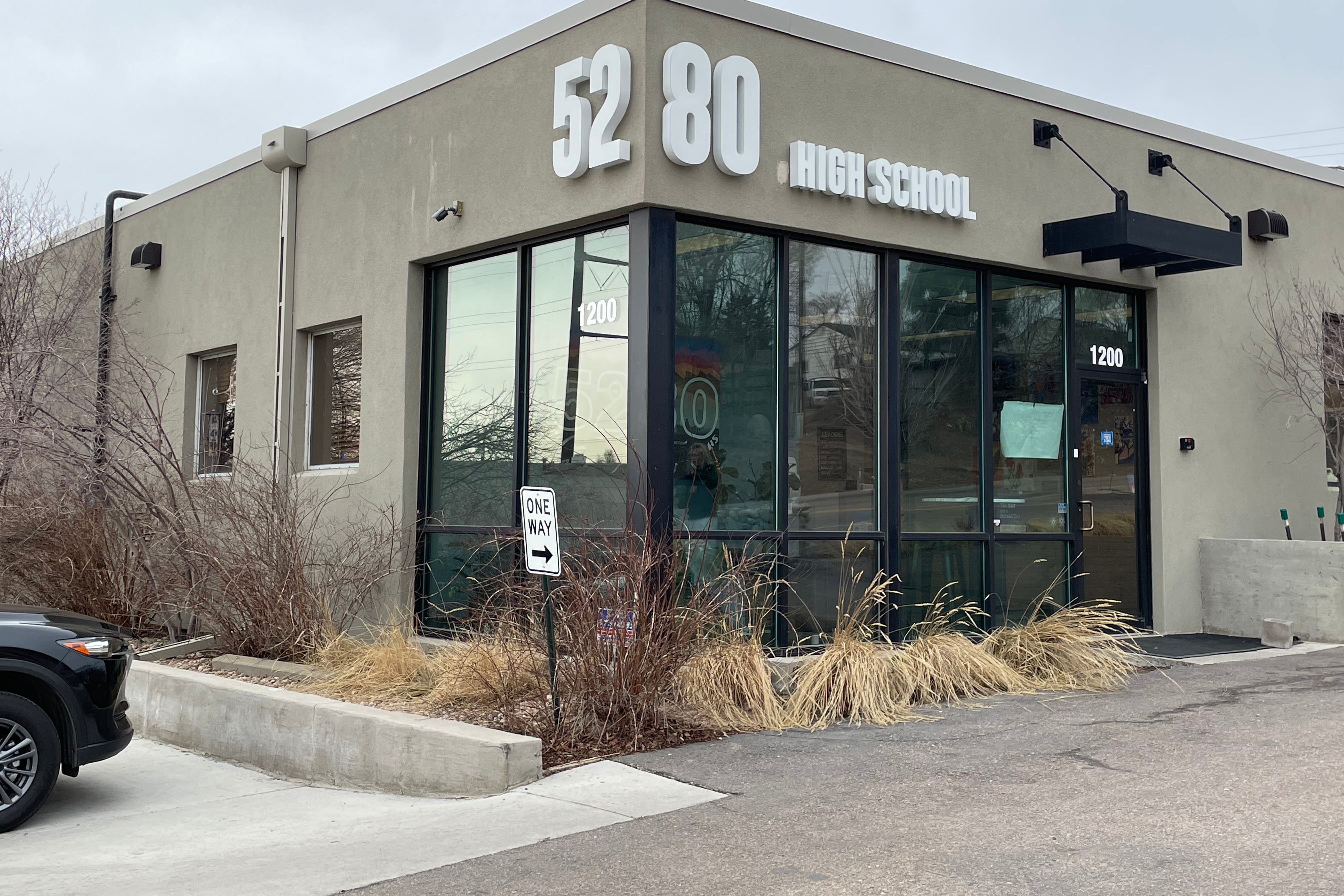 Photo shows the 5280 charter school from a corner angle. It appears to be a gray block building with a large glass window. Large numerals 52 are one side and 80 on the other.