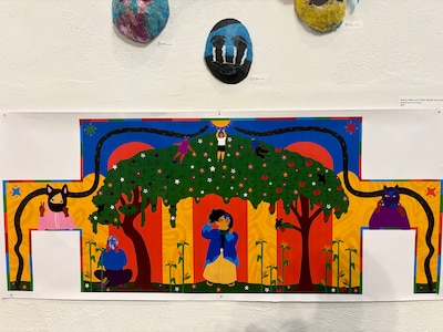 Colorful art hangs on a white wall.