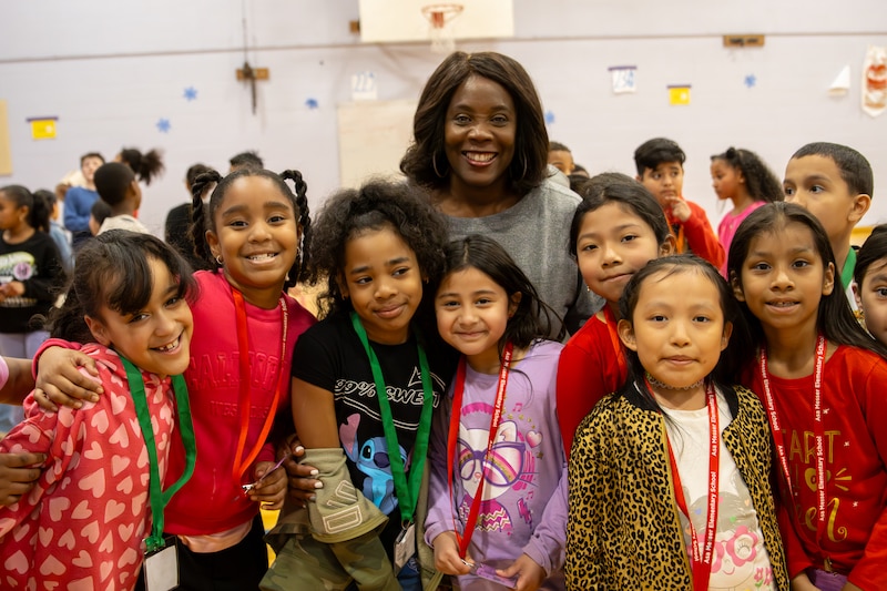 Seven elementary school students stand with their principal at a dance marathon event.
