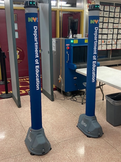 A tall blue metal detector is seen in front of a gray metal detector.