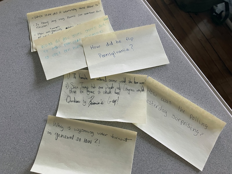 A group of sticky notes with handwritten sentences on a desk.
