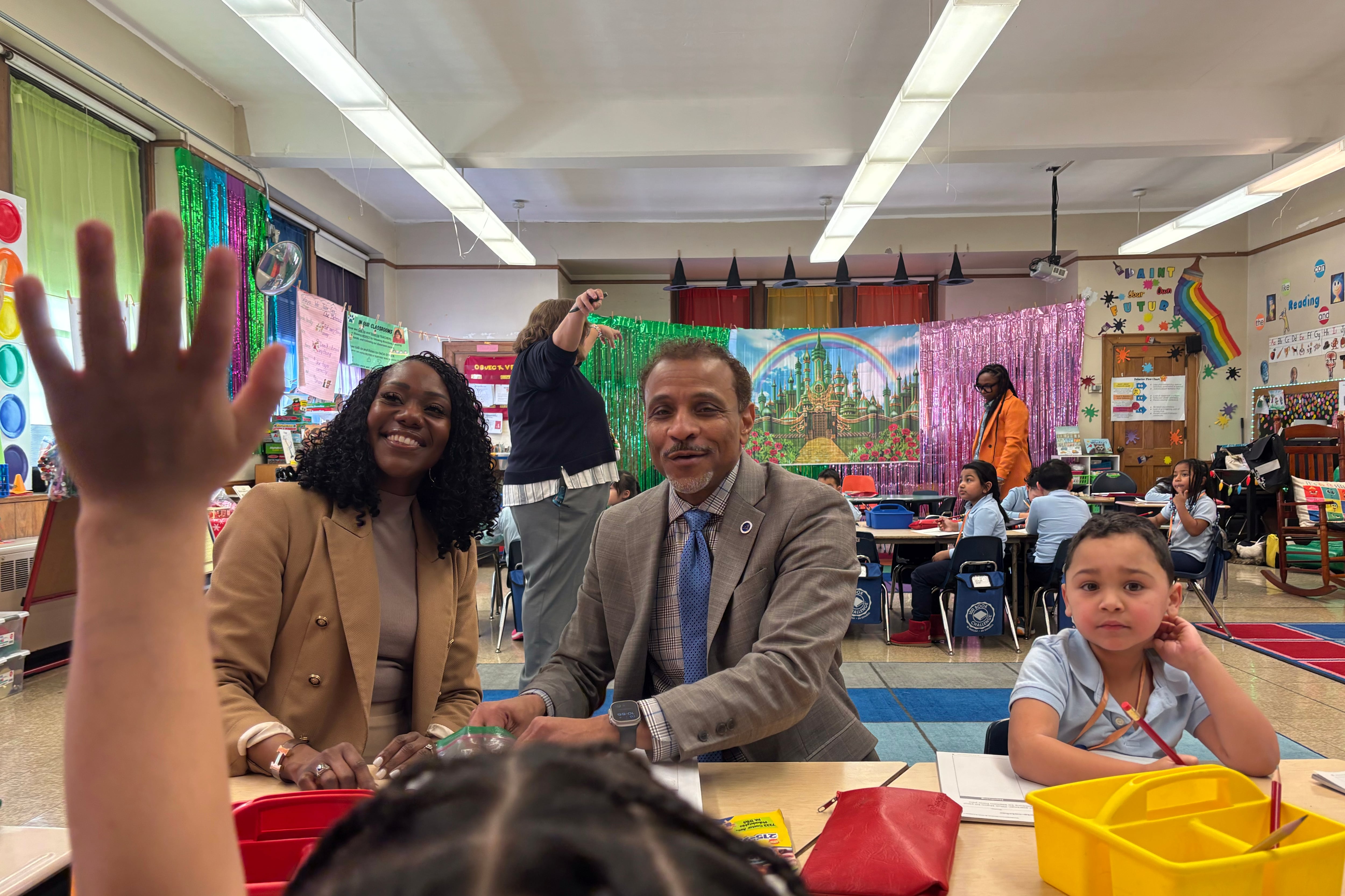 Two adults and a student sit at a small table.