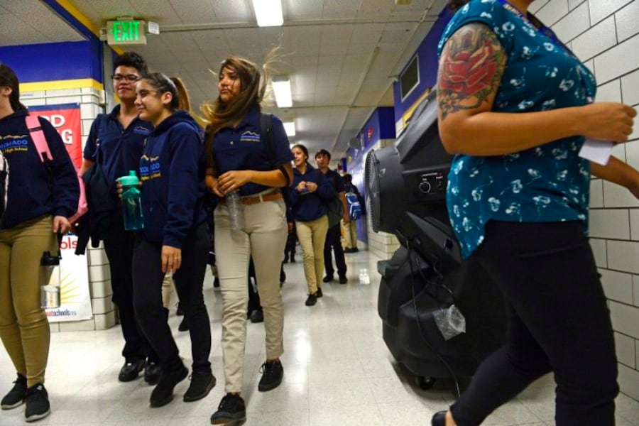 Students walk by large Portacool Cooling systems set up in the hallways of KIPP Denver Collegiate High School on September 24, 2018 in Denver, Colorado.