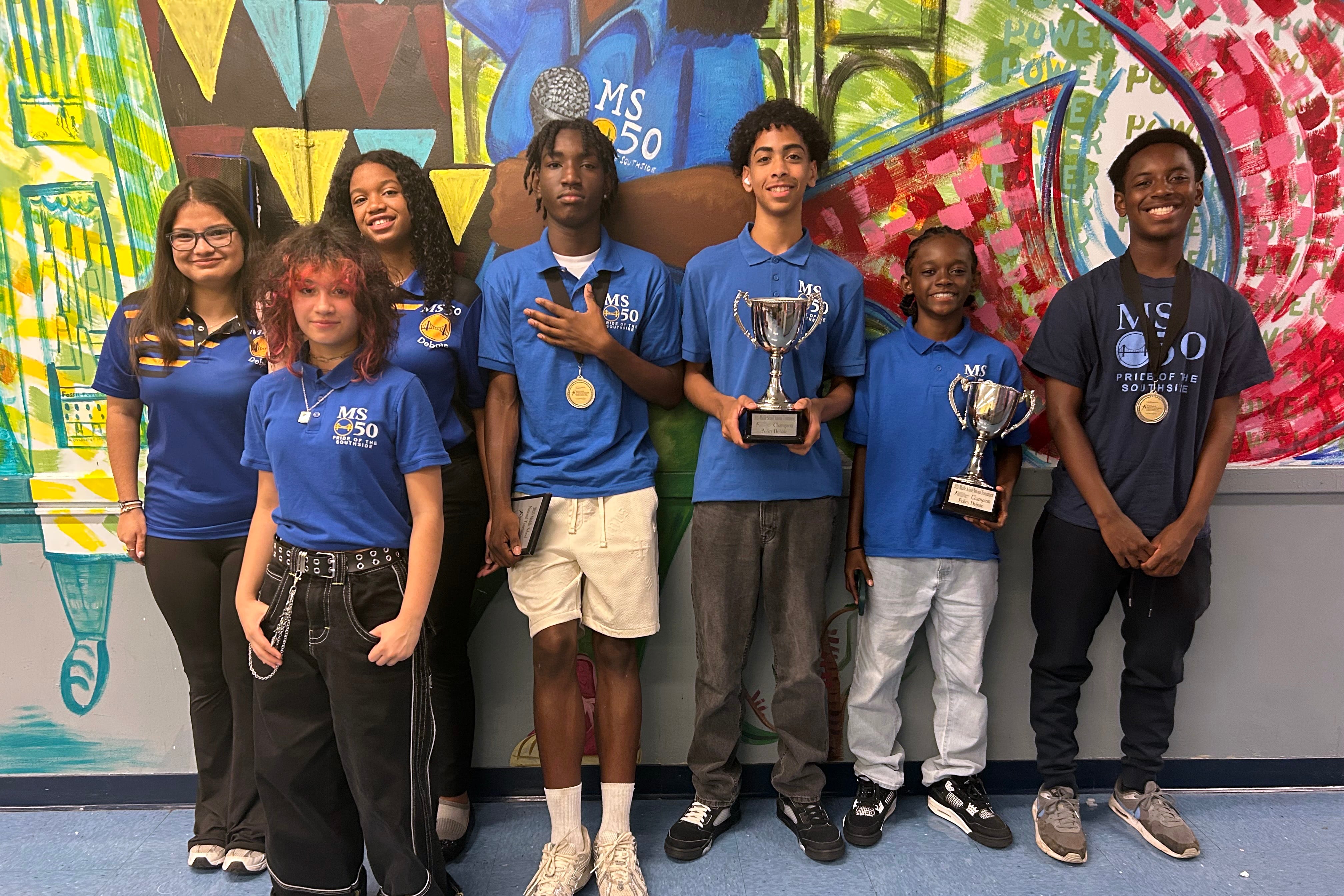 A photograph of a group of middle school students standing together posing for a photograph.