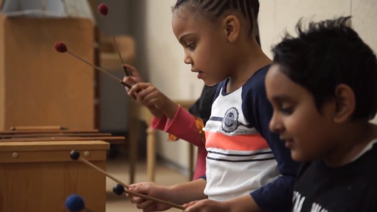 Children play instruments in a classroom in a video by the School Finance Research Collaborative.