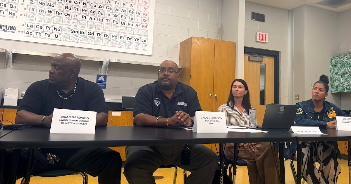 Two men and two women sit at a table with their names.