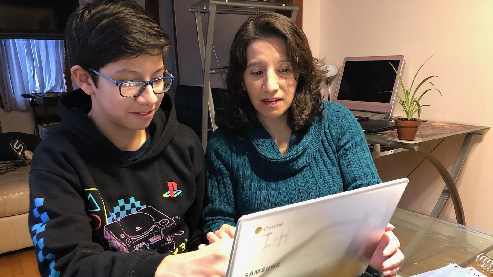 Gabriela Oria helps her son, Alex, a seventh-grader at Madero Middle School, with school work in their Little Village home.