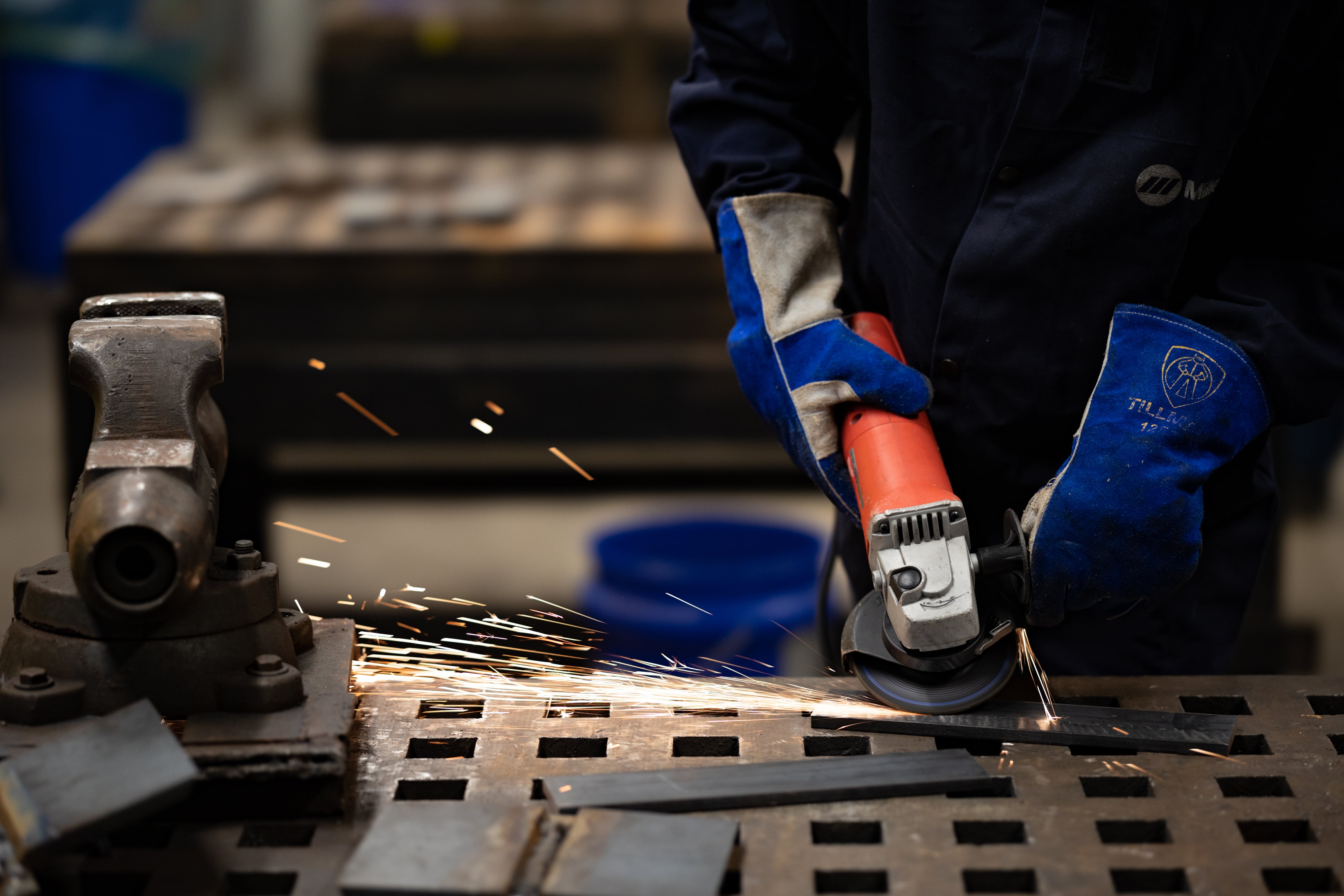 A photograph of a student using a tool in a shop room.